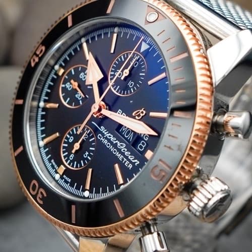 Three-quarter view of a luxury diver watch with ceramic bezel on pebbles